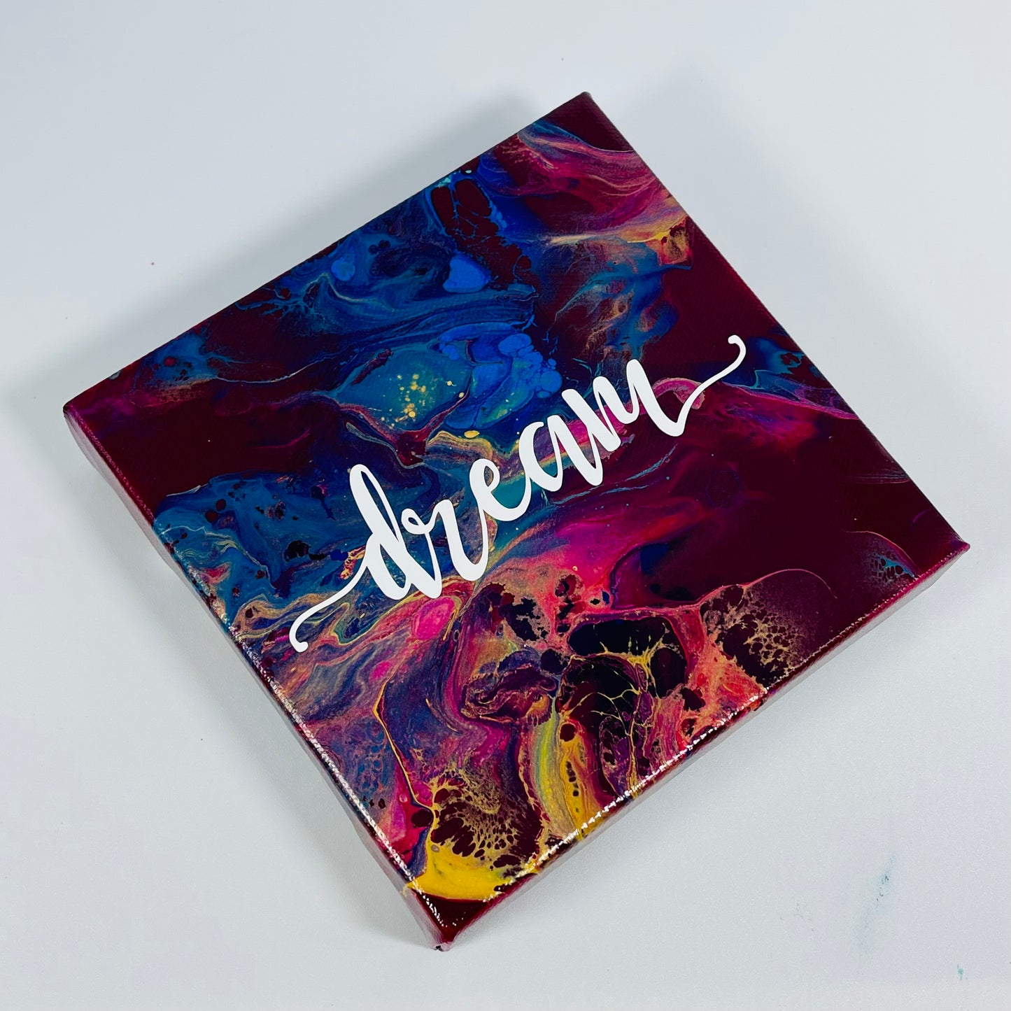 The Desire Dream Block. A colorful hand painted painting that says 'Dream'