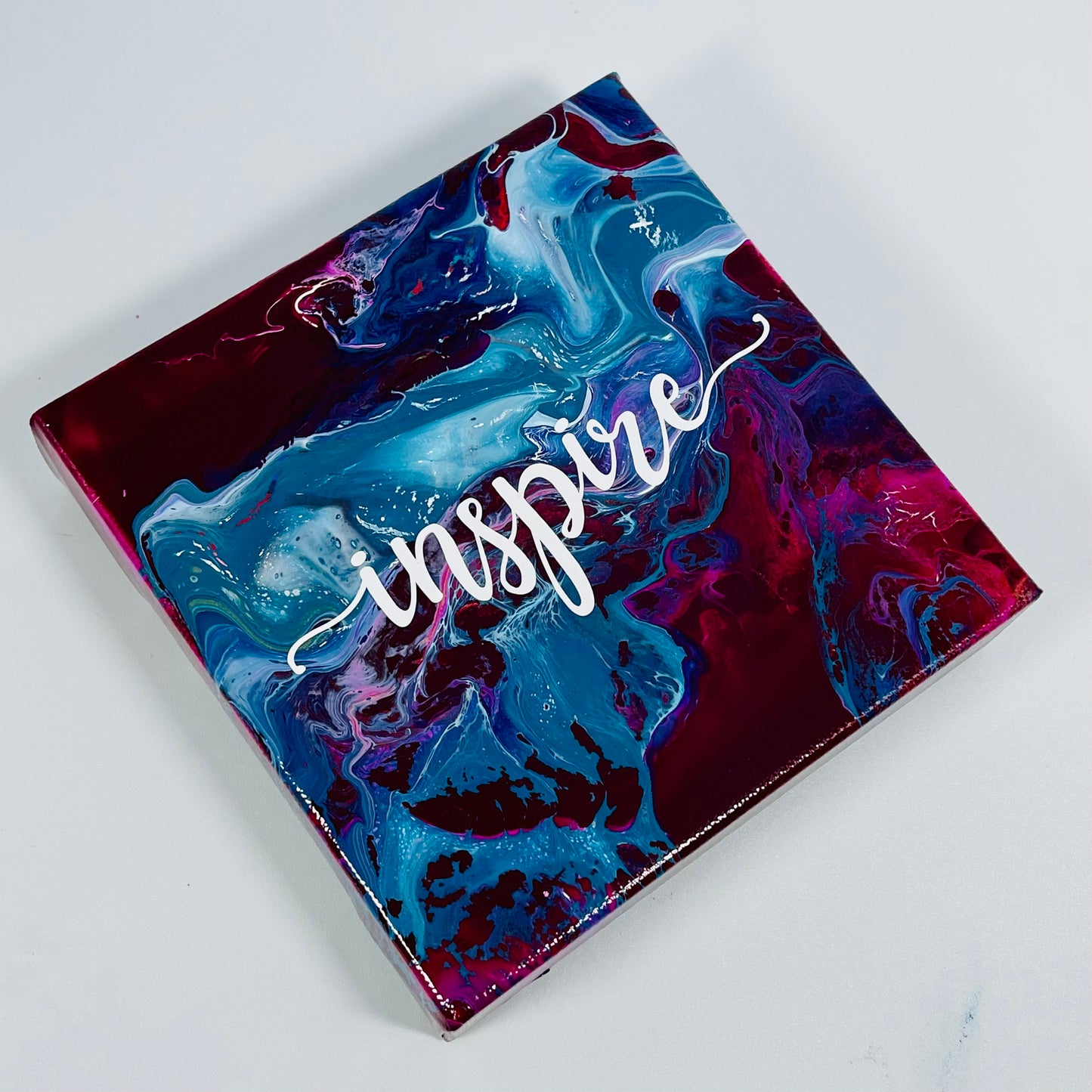 The Indigo Inspire Block. A colorful hand painted painting that says 'Inpire'