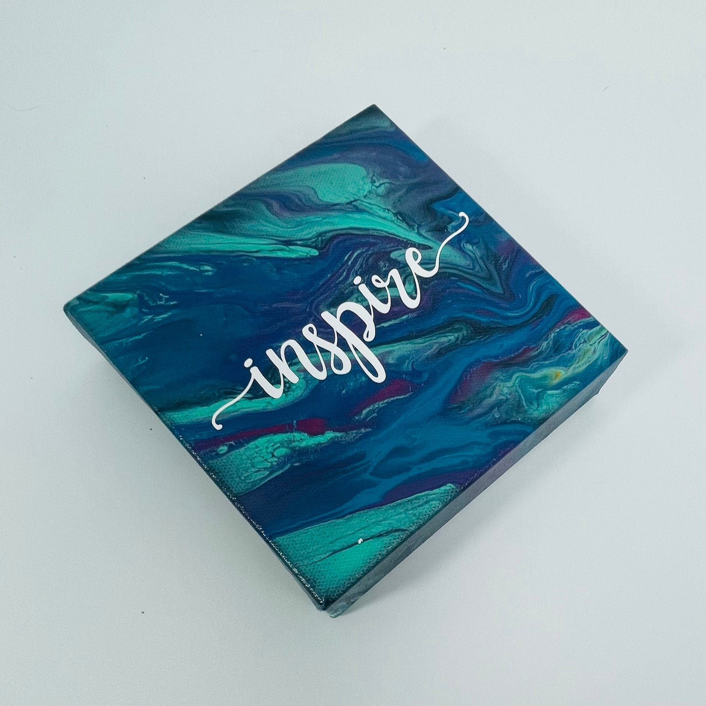 The Oriel Inspire Block. A colorful hand painted painting that says 'Inpire'