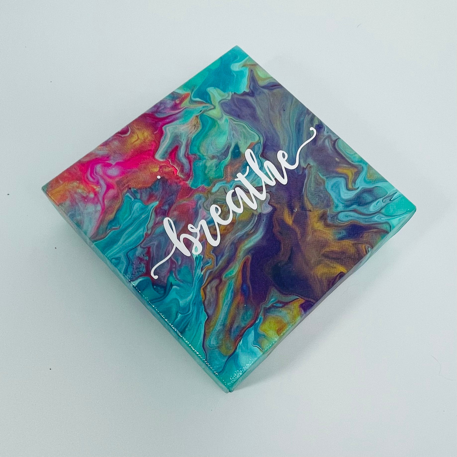 The Aura Breathe Block. A colorful hand painted painting that says 'breathe'