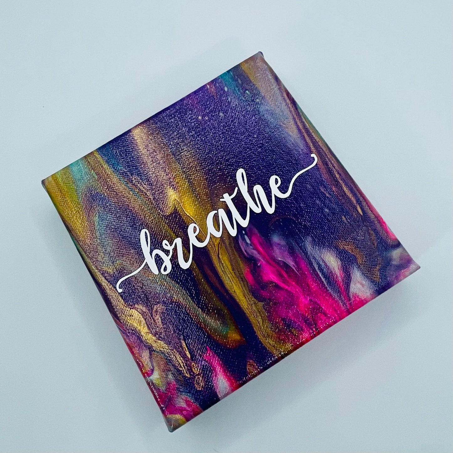 The Satya Breathe Block. A colorful hand painted painting that says 'breathe'